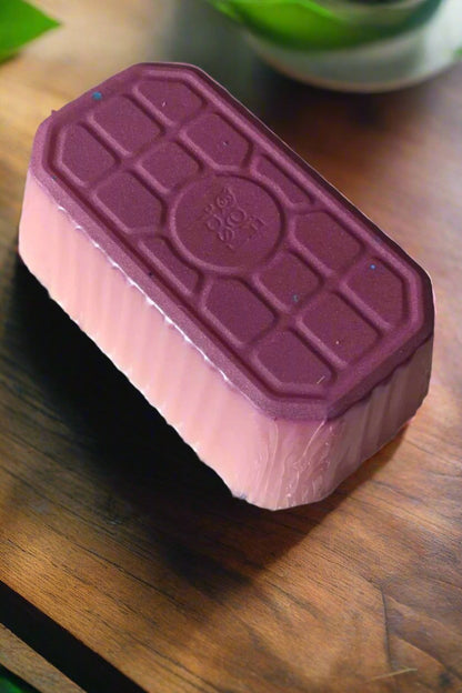 Daisy & Spring Meadows artisan wax melt loaf with pink and purple layers on a wooden surface.